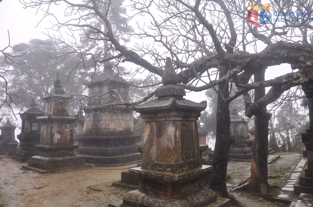 In spring, the temples, shrines, and ancient towers of Yen Tu are often veiled in mist and fine drizzle. The centuries-old frangipani trees stand bare and graceful, their leafless branches creating a serene, almost poetic atmosphere amidst the sacred mountain air.