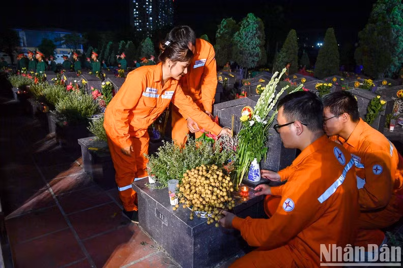 Members of the national power utility EVN offer flowers and incense at the vigil.