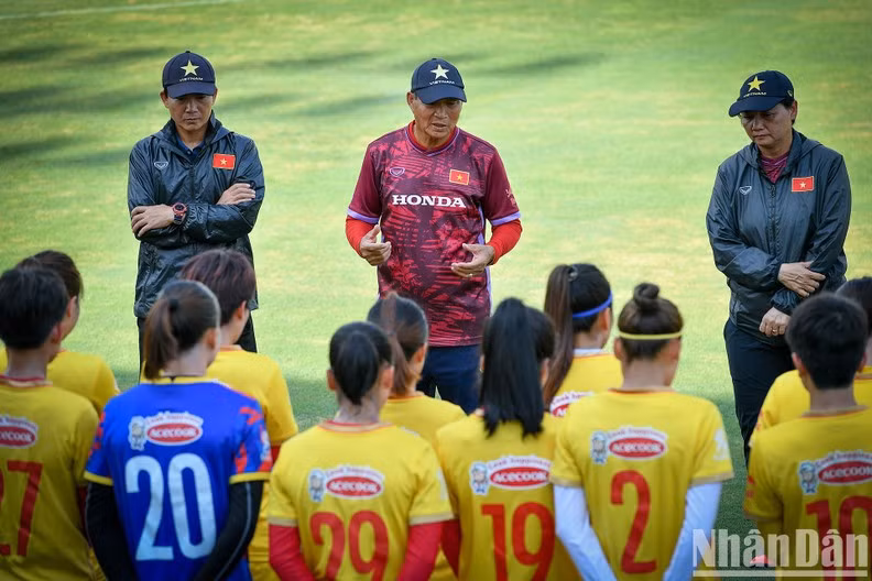 Coach Mai Duc Chung (C) gives instructions to the female football players during the training session.
