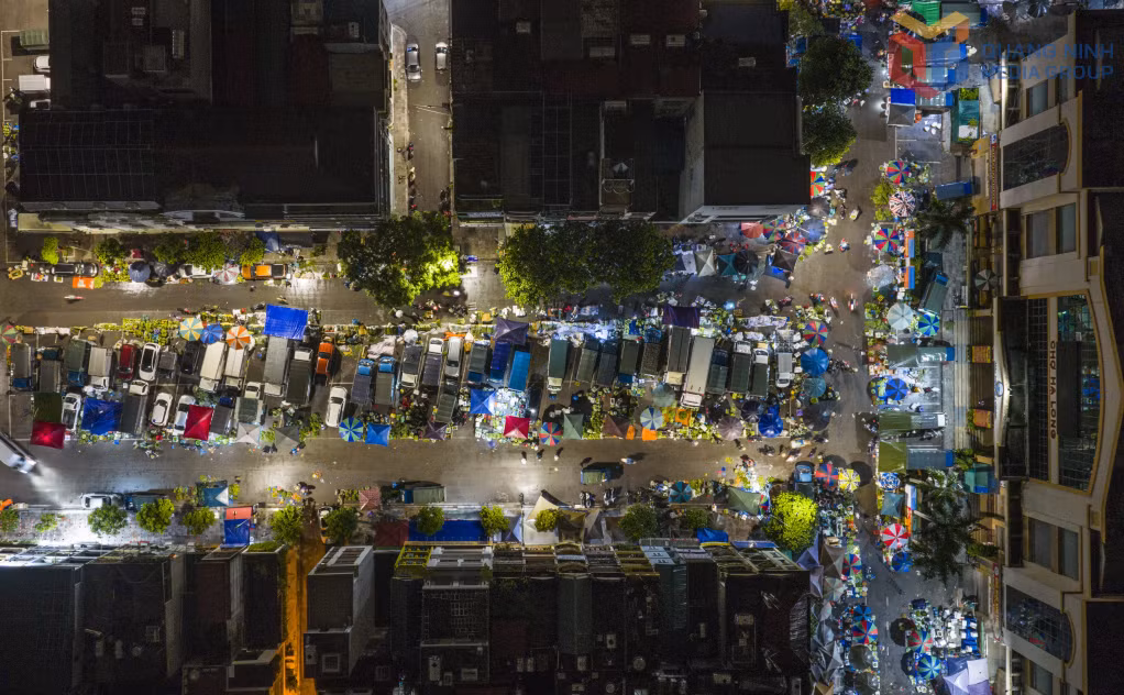 When the streets sleep, Ha Long Market 1 glows under night lights, bustling with buyers and sellers.