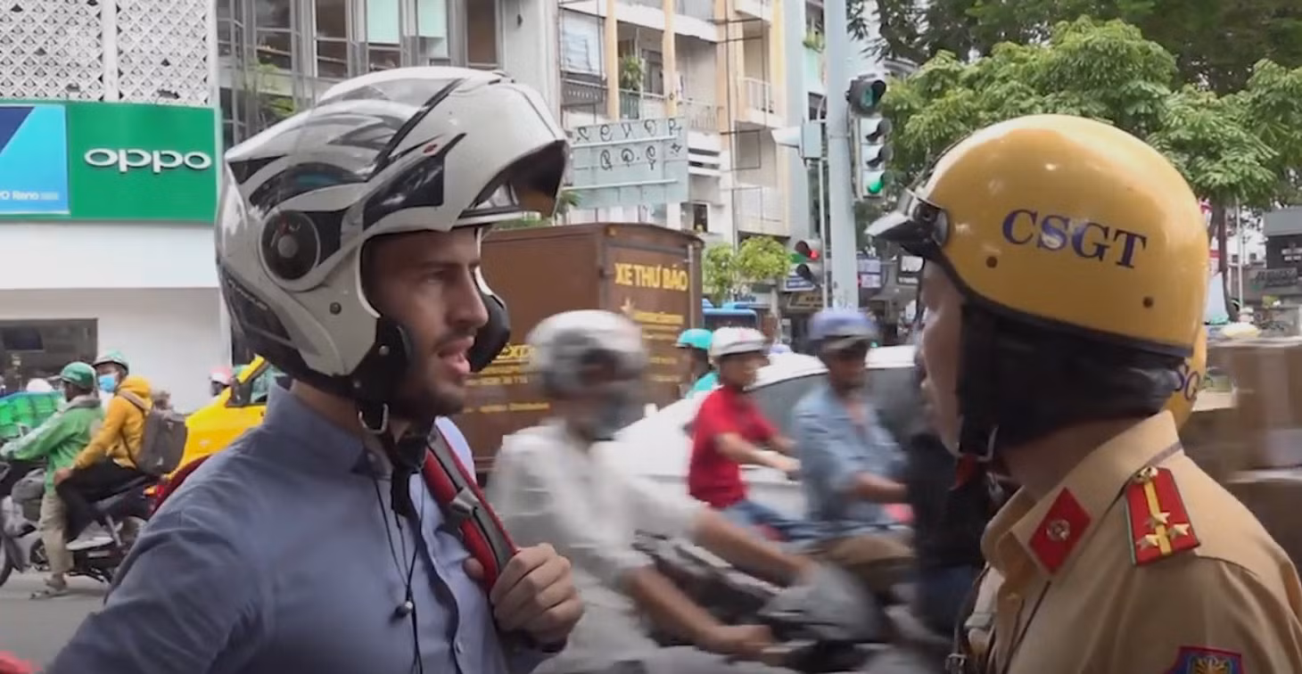 A police officer explains to a foreigner that he is violating the rule while driving without a Vietnamese license in HCMC, August 2019. Photo by VnExpress/Diep Nguyen