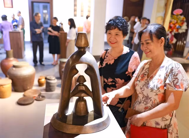 Visitors look at a bronze sculpture at an exhibition at 50 Đào Duy Từ Street, Hoàn Kiếm District.