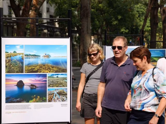 The Colours of Nature exhibition at the pedestrian zone by Hoàn Kiếm Lake attracts foreign tourists.