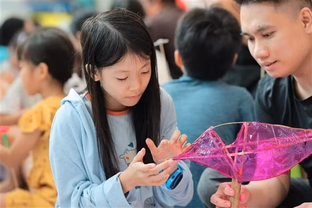 Children experience making fish-shaped lanterns. — VNA/VNS Photo