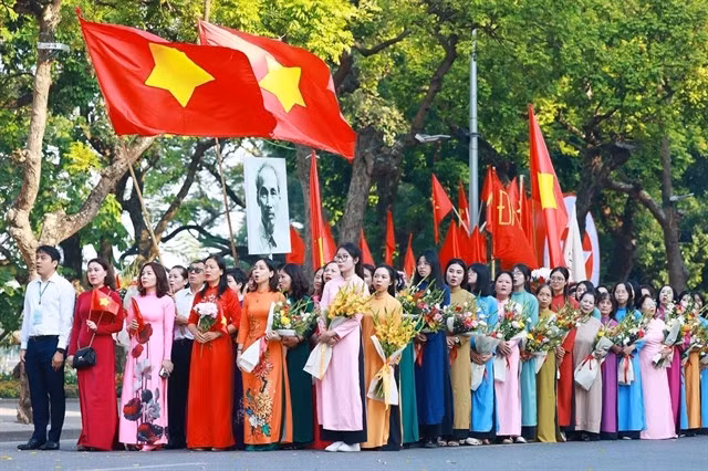 Citizens of the capital salute the national flag and sing the national anthem, reenacting the first flag-raising ceremony in Hà Nội on October 10, 1954. — VNA/VNS Photo