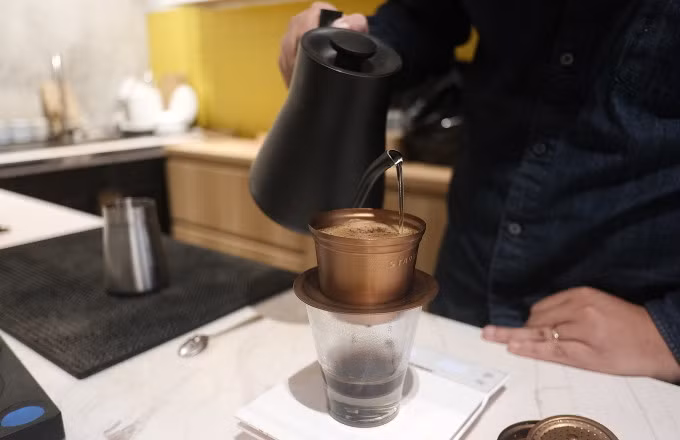 Pham Quoc Cuong makes coffee using a Vietnamese filter called a "phin". Photo by Anh Tu