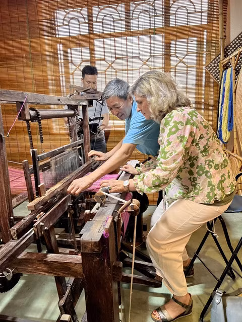 A guest learns how to weave silk.