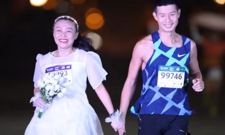 Đặng Anh Quyết and fiancee Phạm Nga run to the finish line of the 2022 VnExpress Hà Nội Midnight Marathon. — Photo vm.vnexpress.net