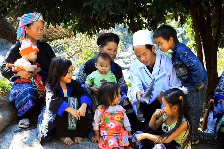 A health worker provides instructions to locals in Ho Bon Commune, Mu Cang Chai District, Yen Bai Province, on how to protect themselves during the changing seasons (Photo: VNA)