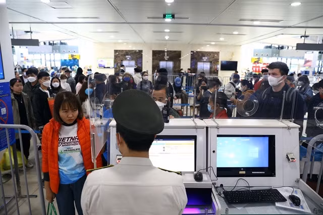 Passengers wait in line at a passport inspection desk of Nội Bài Airport in January. — VNA/VNS Photo Huy Hùng