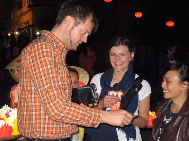 Foreign tourists enjoy releasing candle-lit paper flowers on the Hoài River of Hội An. — VNS Photo Công Thành