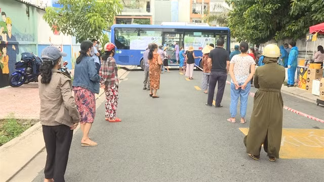 Shoppers wait in line to buy from one of the buses, which together make 10 trips a day. – VNA/VNS Photo