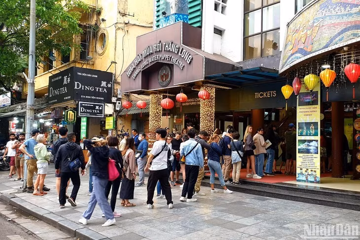 Foreign tourists queue to buy tickets for water puppet shows in Hanoi. (Photo: NDO)
