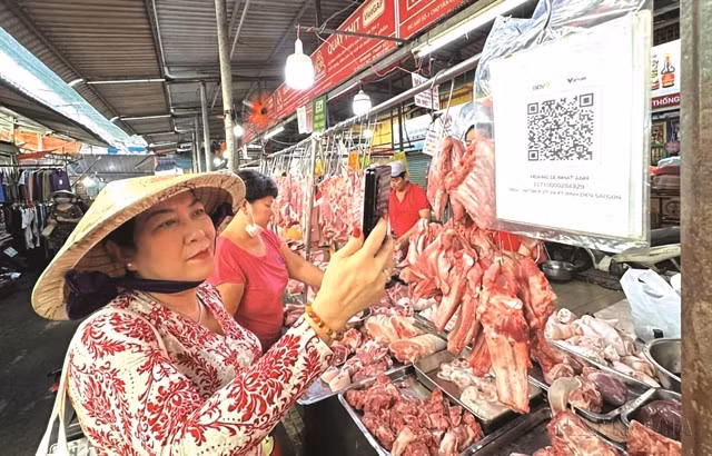 eQUICK AND EASY: Instead of using cash, many residents in Hồ Chí Minh City use cell phones to scan QR codes to make a payment when going to the market. The online market model, Market 4.0, is becoming increasingly popular in the city. VNA/VNS Photo Văn Phúc