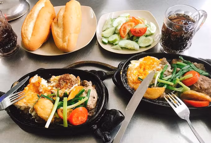 Banh mi served in frying pans at a stall in Hanoi. Photo by Nguyen Chi