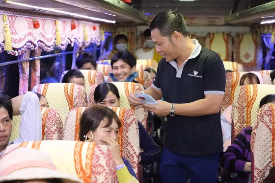 A volunteer supports passengers on coach No 7+. — Photo sggp.org.vn
