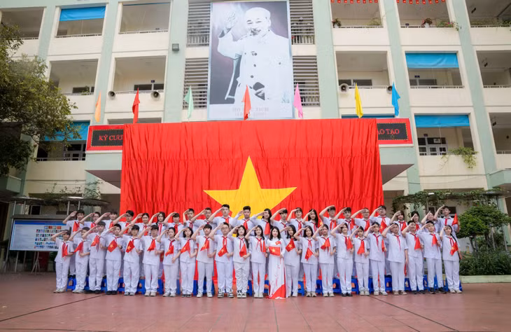 Teachers and students of Trong Diem Secondary School gather beneath a 54-square-meter national flag to express their gratitude and patriotic spirit.