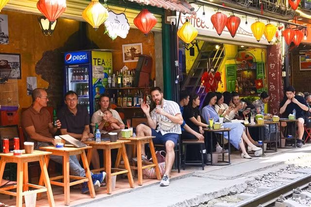 Foreign tourists enjoying the drinks on the cafes along the famous 'train track street' in downtown Hà Nội in March 2025. — VNA/VNS Photo Ngọc Anh