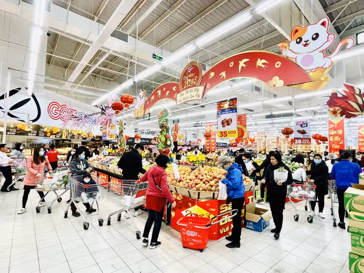 Supermarkets are decorated with eye-catching items, people are busy shopping on the day before Tet.