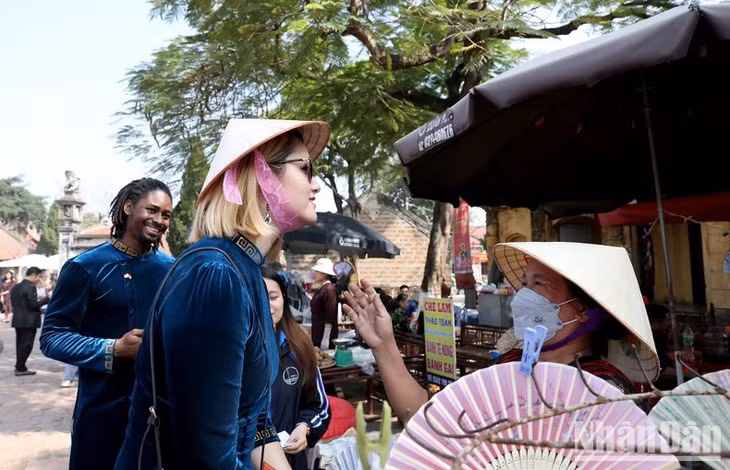 Hyomi from the US brings herself a conical hat at the country market.