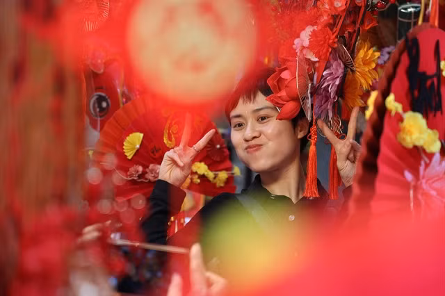 A woman poses a shop selling decoration items in Hàng Mã Street, Hà Nội. VNS Photos Vân Nguyễn