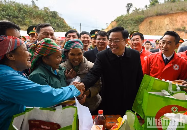 National Assembly Chairman Vuong Dinh Hue shakes hands with members of the ethnic community in Trinh Tuong.