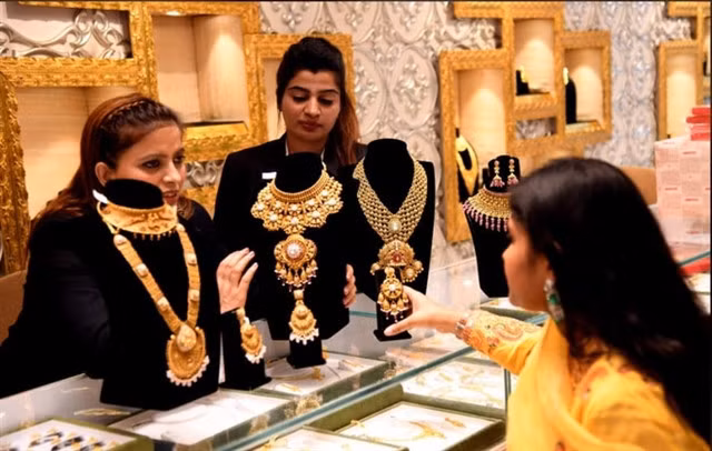 People purchase gold jewellery at a store in Bhopal, India. XINHUA/VNA Photo