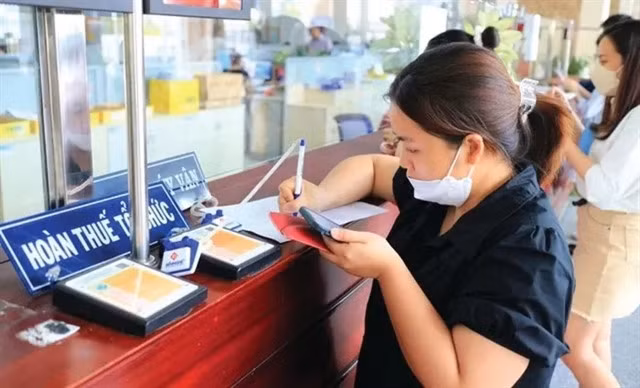 Business representatives fill out forms at a tax office in HCM City. VGP Photo