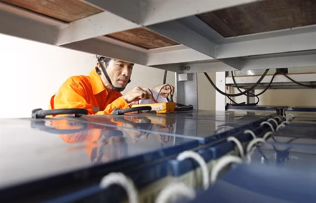 Võ Hoàng Tuấn, deputy head of the technical department at Ninh Thuận Power Company, checks the batteries at Song Tử Tây power station. — VNA/VNS Photo Thanh Vũ
