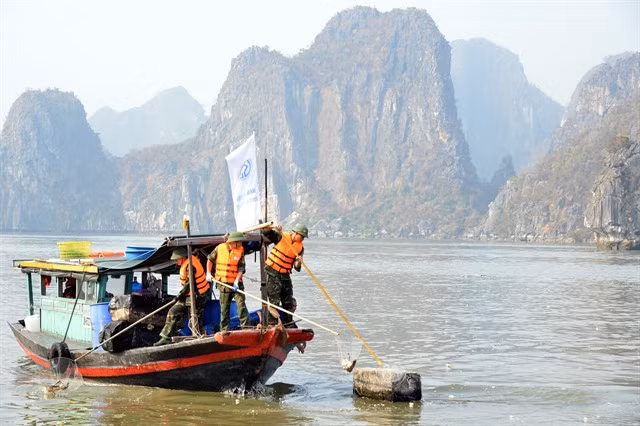 Military officers are involved in the cleanup of the waste and garbage washed into Ha Long Bay during typhoon Yagi.
