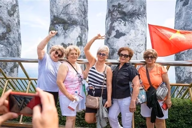 Foreign tourists pose for a photo on the world-famous Golden Bridge inside Ba Na Hills Sun World complex in Da Nang city (Photo: VNA)