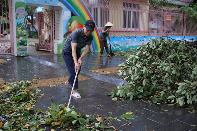 People in Nam Định Province clean up on Sunday morning after the typhoon hit the northern region.