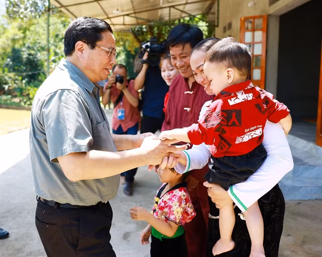 Prime Minister Phạm Minh Chính and a Tày ethnic family in Hòa Bình Province during his working visit on Sunday. —VNA/VNS Photo Dương Giang
