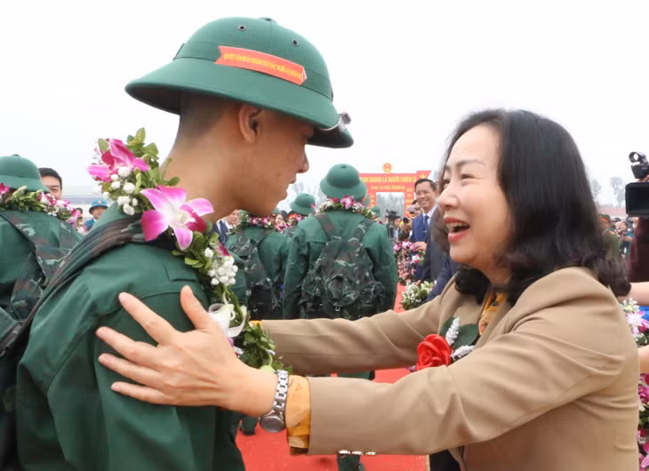Member of the Provincial Party Standing Committee and Permanent Vice Chairwoman of the Provincial People's Council, Vi Ngoc Bich, presented flowers to the new recruits as they embarked on their military service in Quang Yen town.