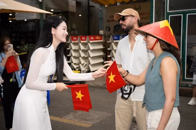 International tourists receive national flags on HCM City's Book Street. — VNA/VNS Photo