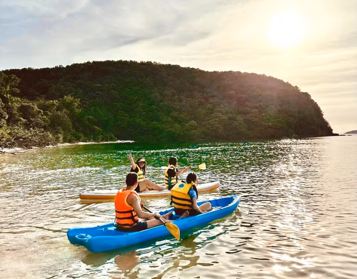 Tourists go kayaking to explore the clear blue waters of Thanh Lan beach.