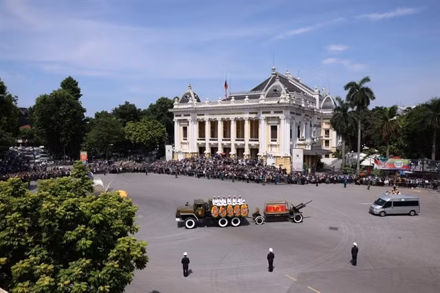 The entourage passes the Hà Nội Opera House.