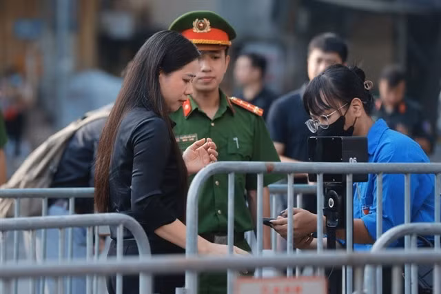 Youth Union members help the people scan QR codes before entering the National Funeral Hall to pay tribute to Party General Secretary Trọng. — VNA/VNS Photo Minh Quyết