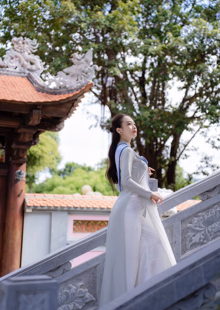 The contestants walked on the marble steps, behind them was the curved yin-yang tiled roof of Vung Duc Temple.
