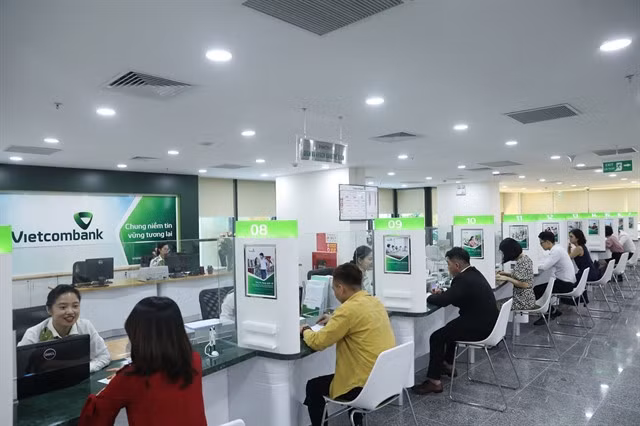 Customers make transactions at a Vietcombank office in Hà Nội. Interest rate for short-term deposits from 1-2 months at Vietcombank is currently only 1.9 per cent per year, a decrease of 0.3 percentage points compared to the previous week. — Photo tapchitaichinh.vn