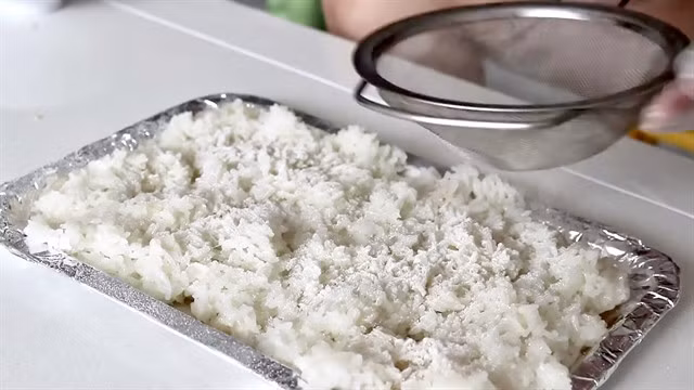 A special yeast for making cơm rượu is thoroughly sprinkled on cooked glutinous rice before a three-day fermentation. VNS Photo Gia Linh