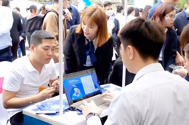 A resident in Hà Nội registers for his digital signature with the help from technology company staff. — VNA/VNS Photo