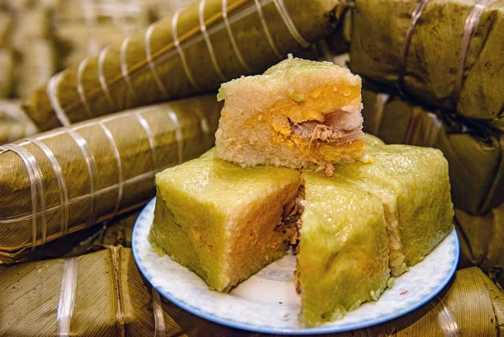 Once cut, banh chung reveals a contrasting light color against its dark green exterior (a product of the banana or dong leaves it’s wrapped in). Photo by VnExpress/Thanh Hue