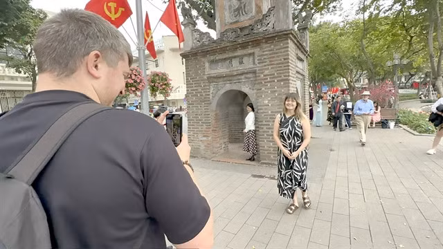 Nerijus Petrokas, from Lithuania, takes photos of Waleria Hjelm, from Denmark, by Hoàn Kiếm Lake in Hà Nội. VNS Photo Lê Hương