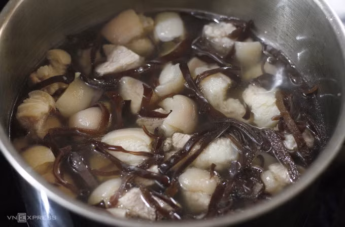 Letting the wood ear mushrooms cook in the pork broth will help them soften up. Photo by VnExpress/Bui Thuy