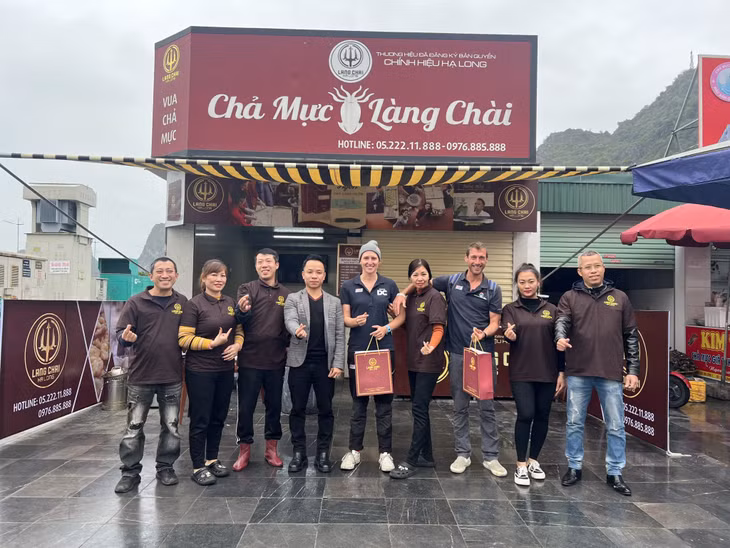 Two skippers took a check-in photo with professional chả mực makers who guided them to make the dish themselves.