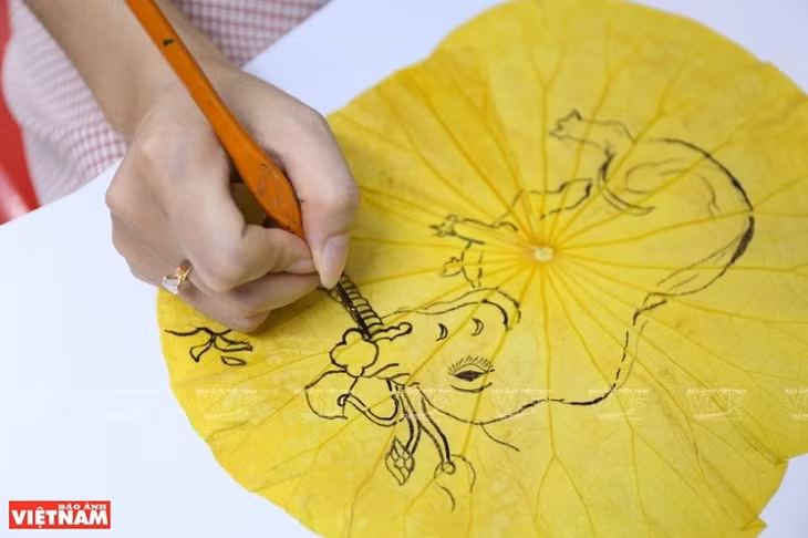 With an ambition to introduce unique artworks to international friends, Kieu Cao Dung has also combined lotus leaves with traditional products such as non la (conical hats), Dong Ho paintings and calligraphy. (Photo: VNA)