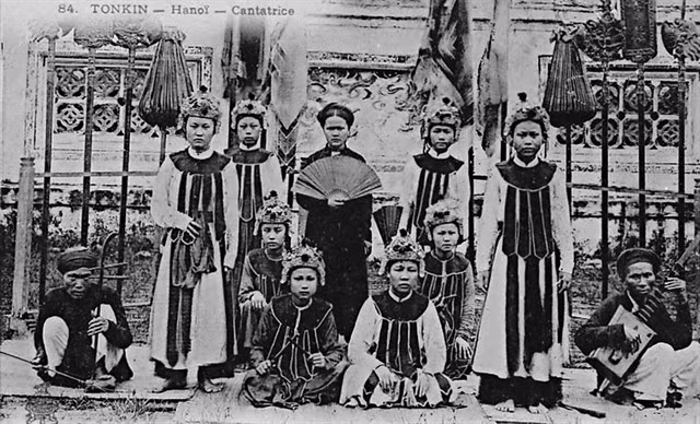 A female singer (centre) and a folk music band in Hà Nội (1884).