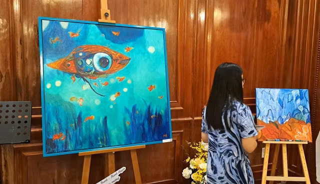 A visitor at flutist Lê Thư Hương's first solo art exhibition 'Dưới Nước' (Underwater). VNA/VNS Photo Thắng Sơn