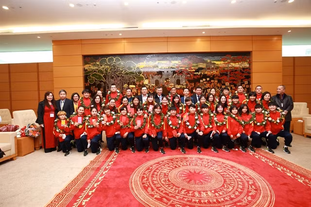 The members of Việt Nam team pose for photos. They were welcomed home as national heroes.